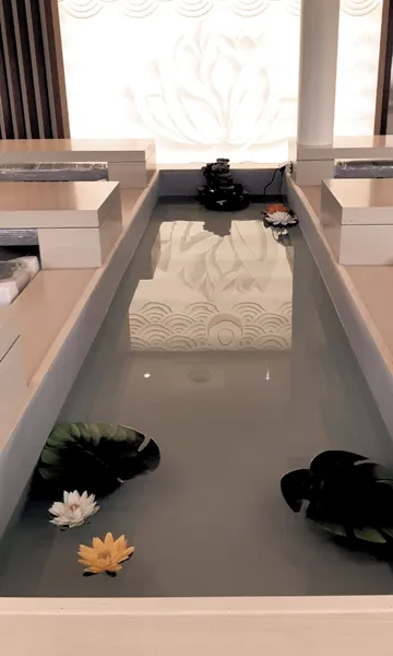 La salle zen : bassin, fleurs de lotus et paroi blanche